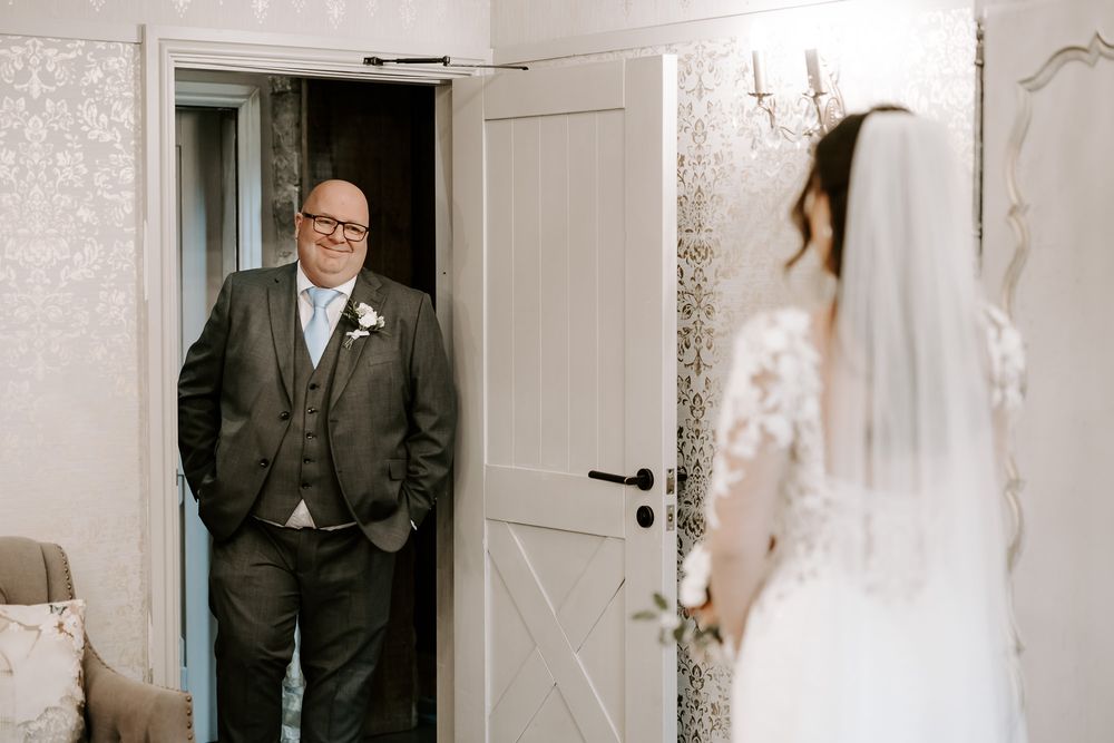 Elegant wedding venue interior with white walls and doorways draped in romantic bridal decorations.