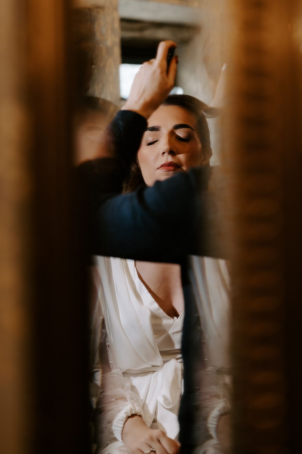 Intimate silhouette shot of a couple in dramatic shadows against wooden slats and warm lighting.