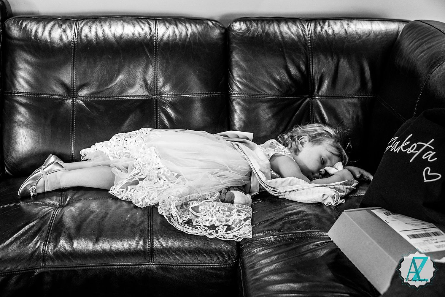 Black and white photo of someone resting peacefully on a leather couch with dramatic lighting.