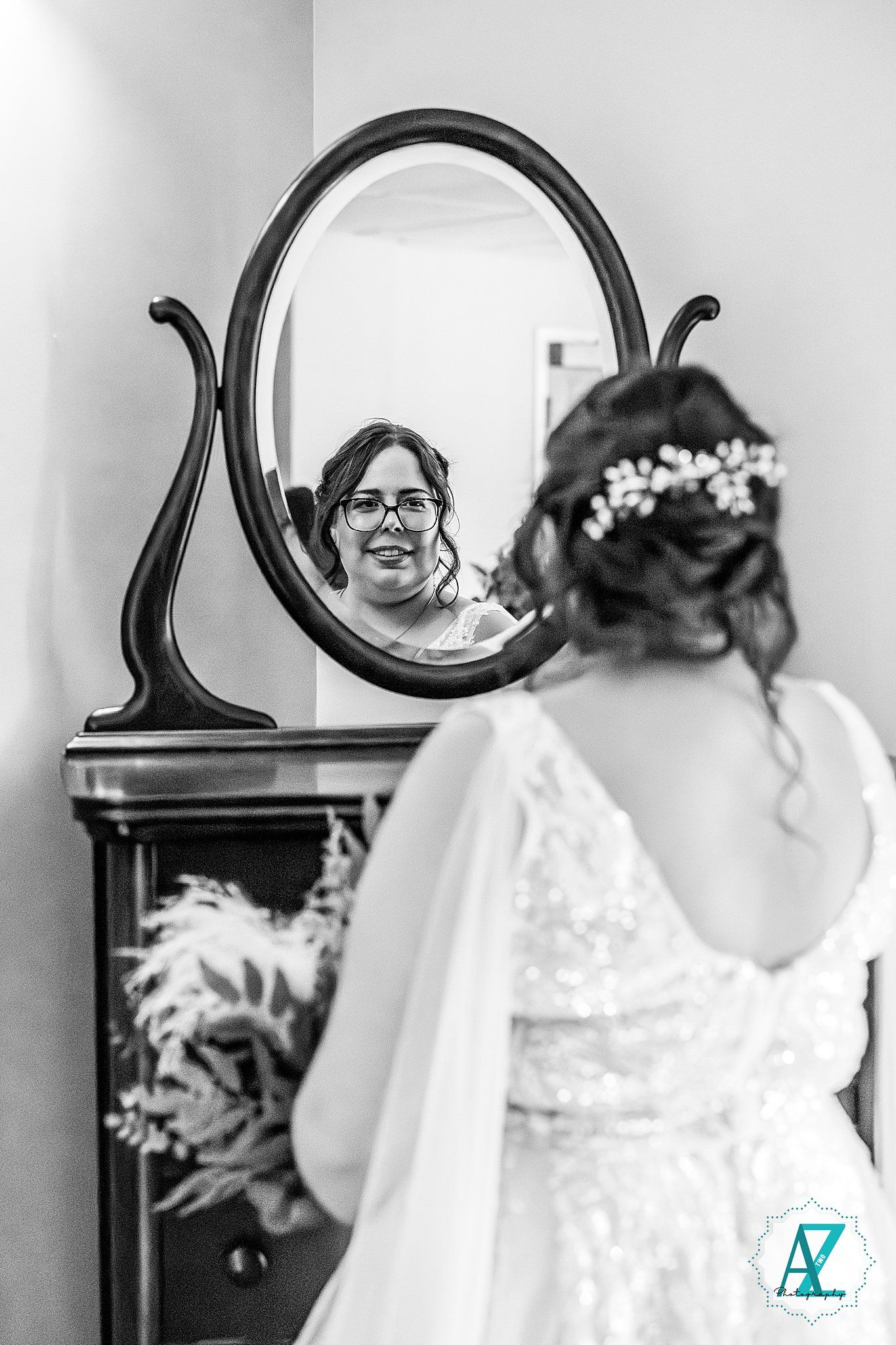 A series of black and white photos showing the back of a bride getting ready with her hair styled in an elegant updo.