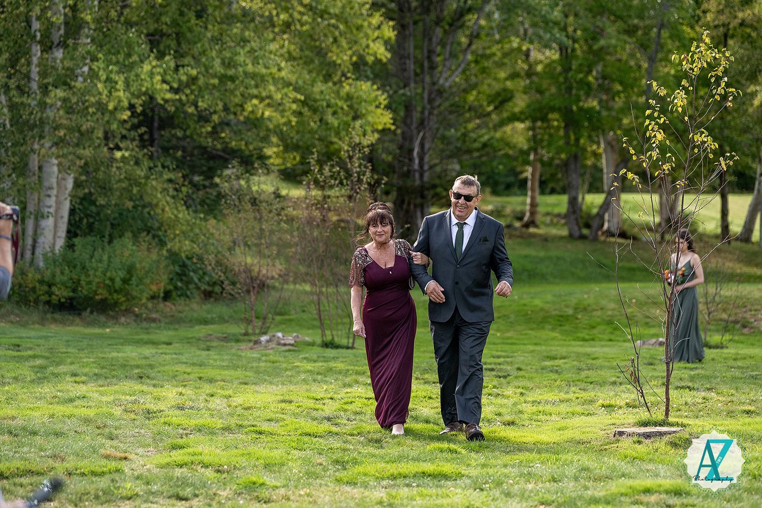 People walk together on lush green grass while enjoying a sunny day in a peaceful park setting.
