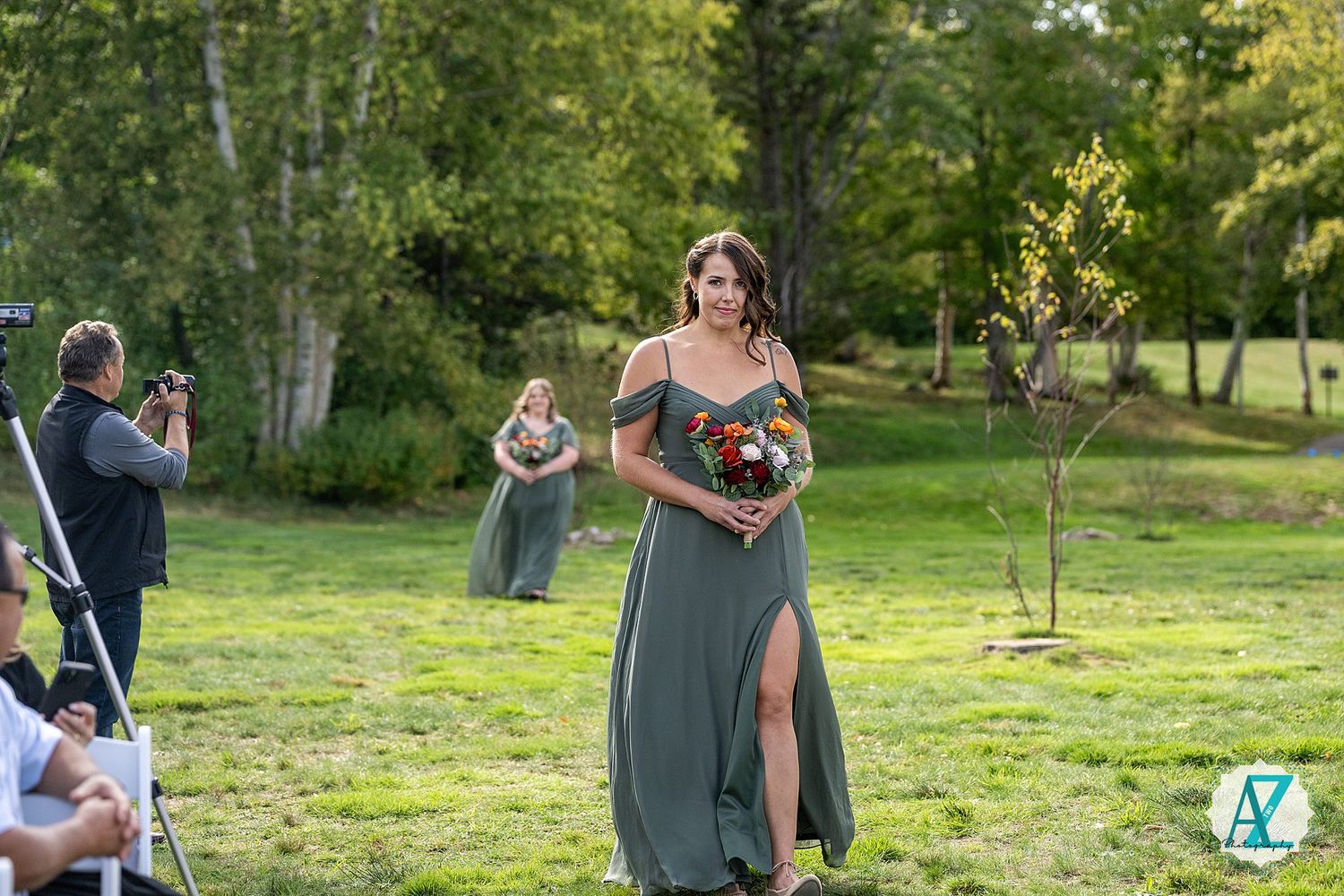 A couple embraces in a romantic outdoor photoshoot amidst lush green grass and trees on a sunny afternoon.