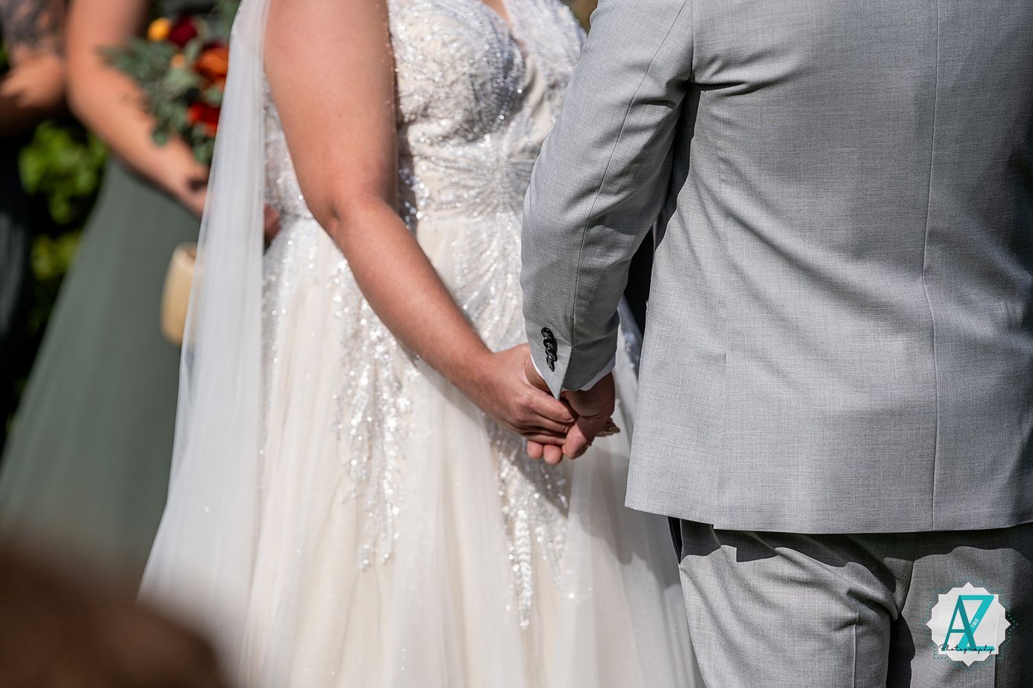 A couple in formal wedding attire stand close together during an intimate indoor ceremony moment.