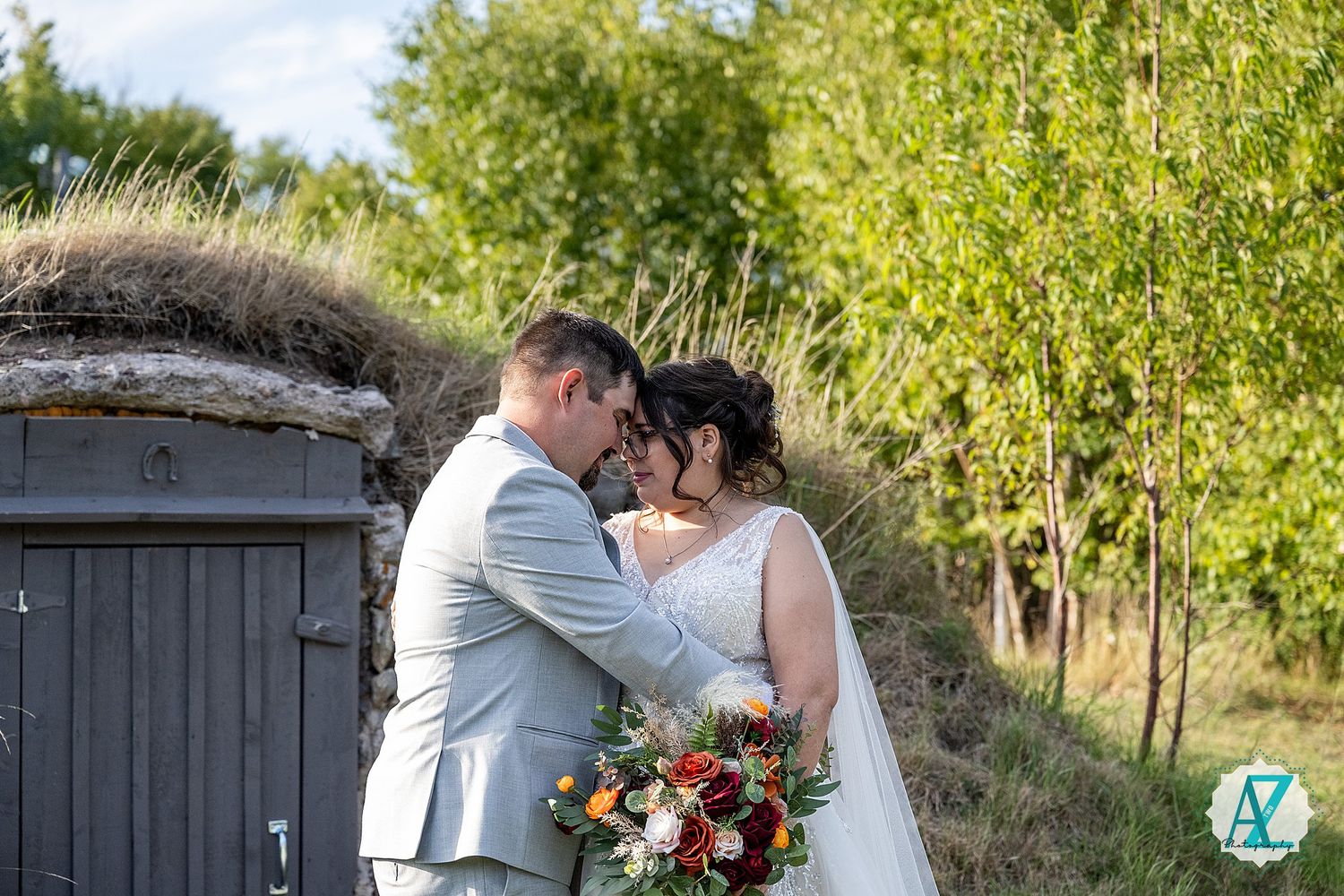 Romantic wedding photo shoot in a rustic outdoor setting with dark wooden doors and greenery.