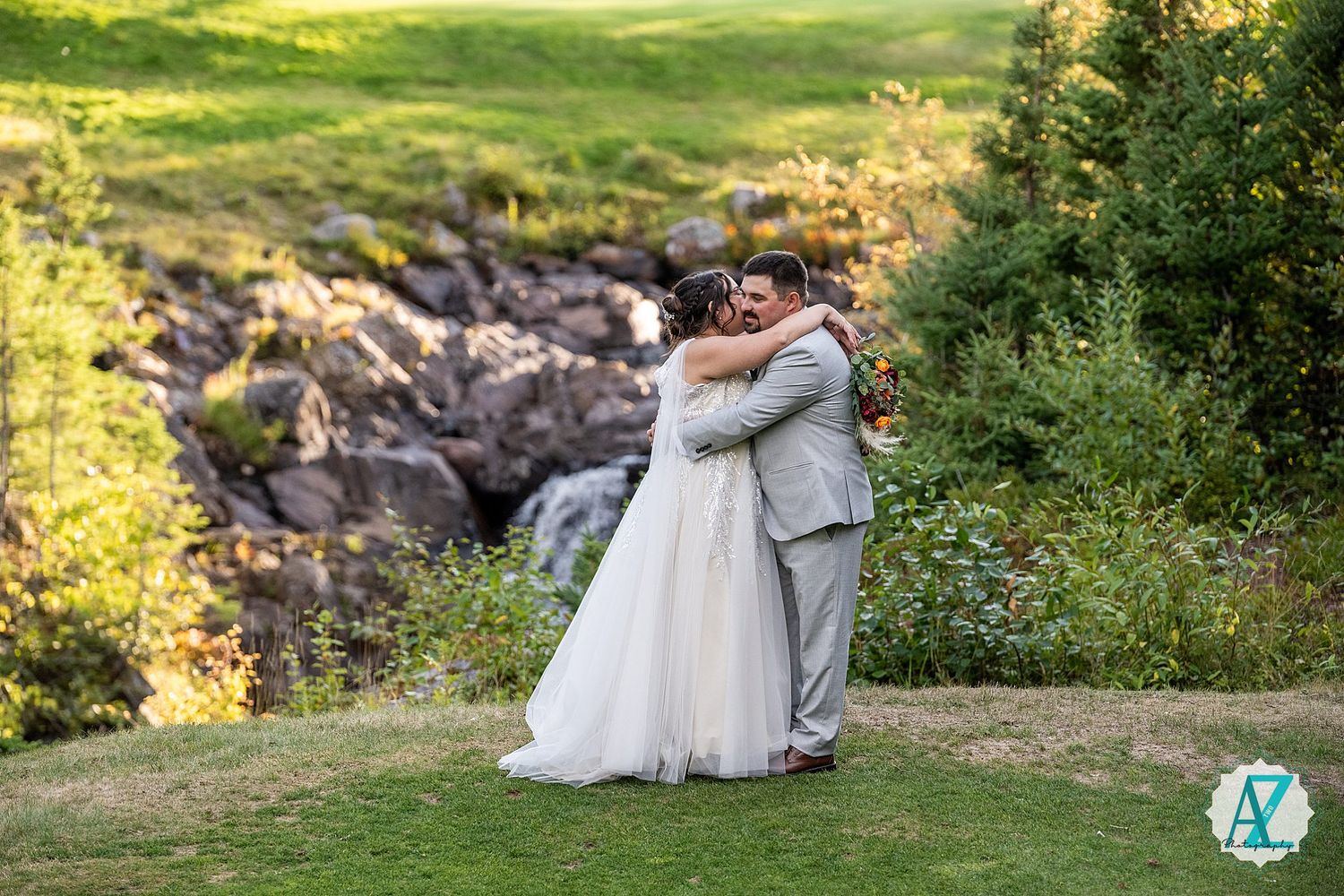 A couple enjoying a romantic moment together on a scenic outdoor hillside during golden hour lighting.
