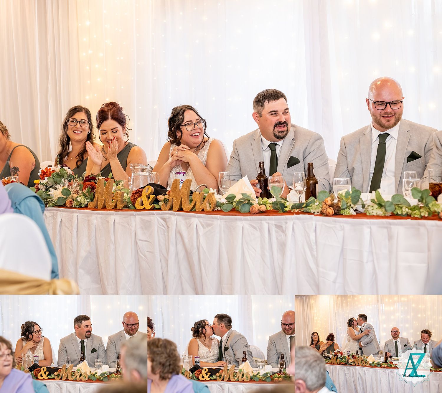 Wedding party members seated at a long head table during reception with floral decorations and table settings.