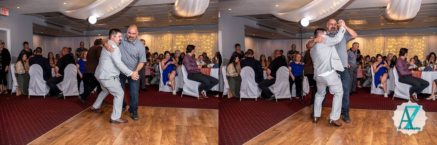 A large dance party with people celebrating on a wooden dance floor under hanging paper lanterns.