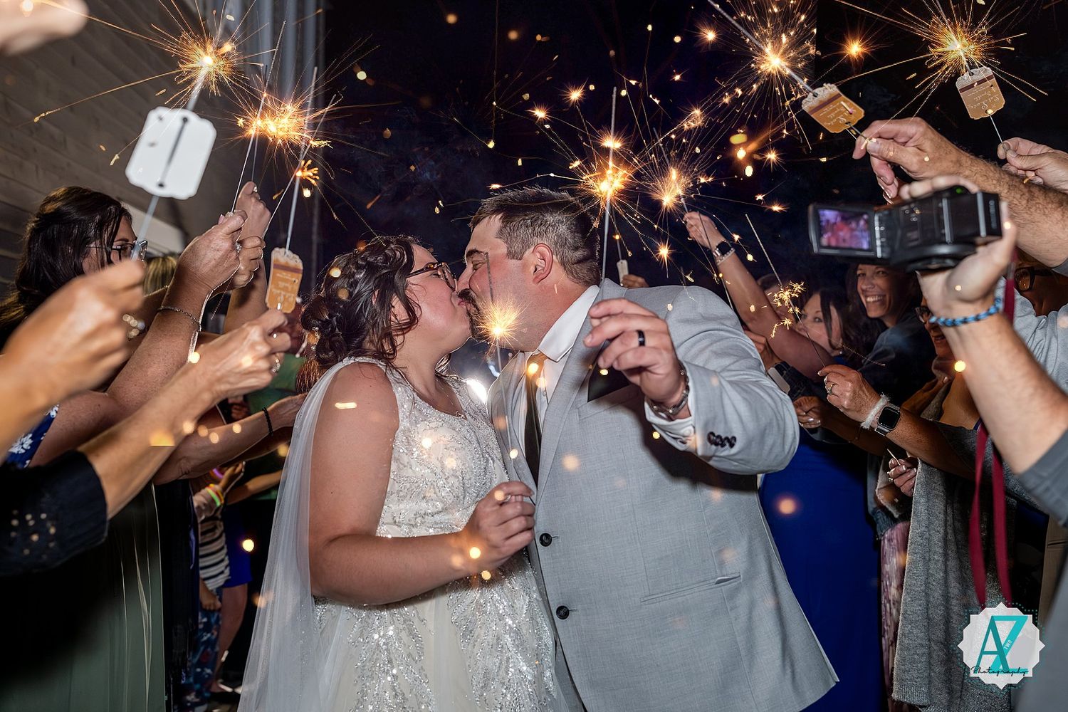 Wedding guests holding sparklers creating magical light trails during an evening celebration.