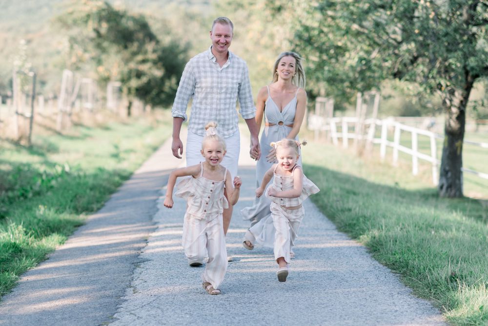 Family walking together on a country path surrounded by green scenery.