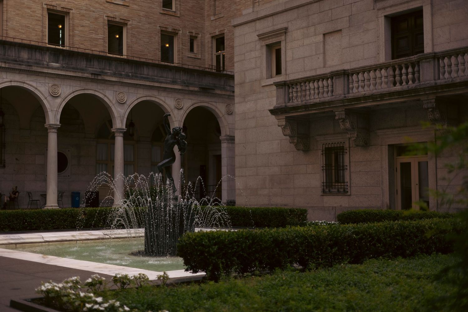 Architectural details of a historic stone building featuring arched windows, columns, and decorative balconies.