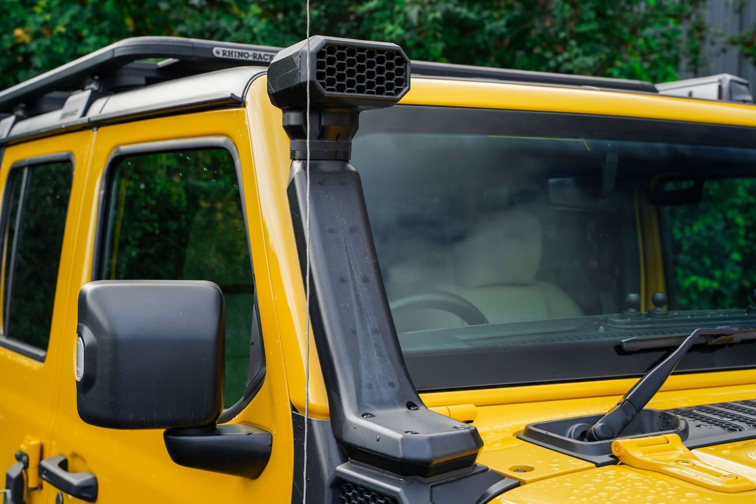 Side profile of a bright yellow Jeep Wrangler Rubicon with black trim accents.