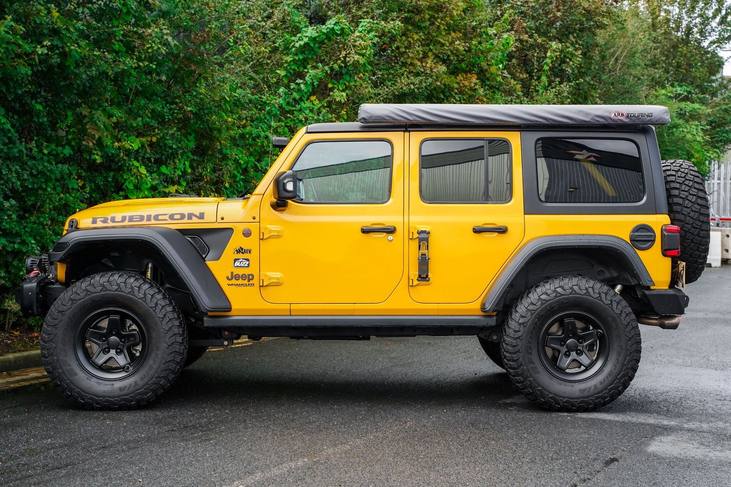 Side profile views of a modified yellow Jeep Wrangler showcasing its aggressive stance and off-road capabilities.