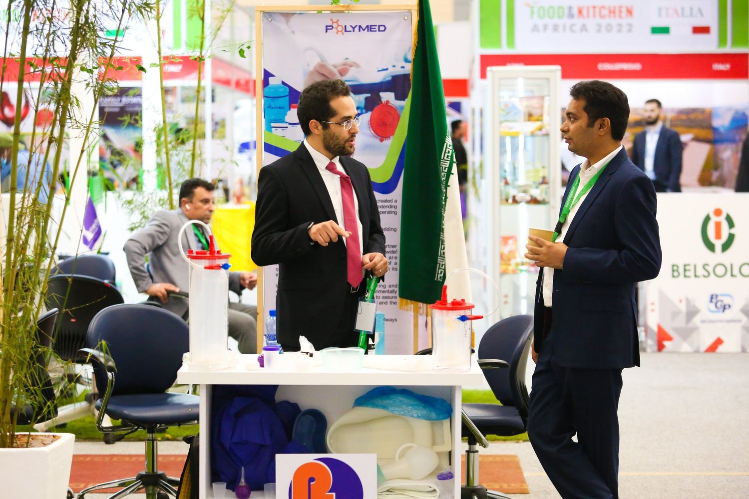 Business professionals network and connect at a construction industry conference in Kenya with teal banners and signage.