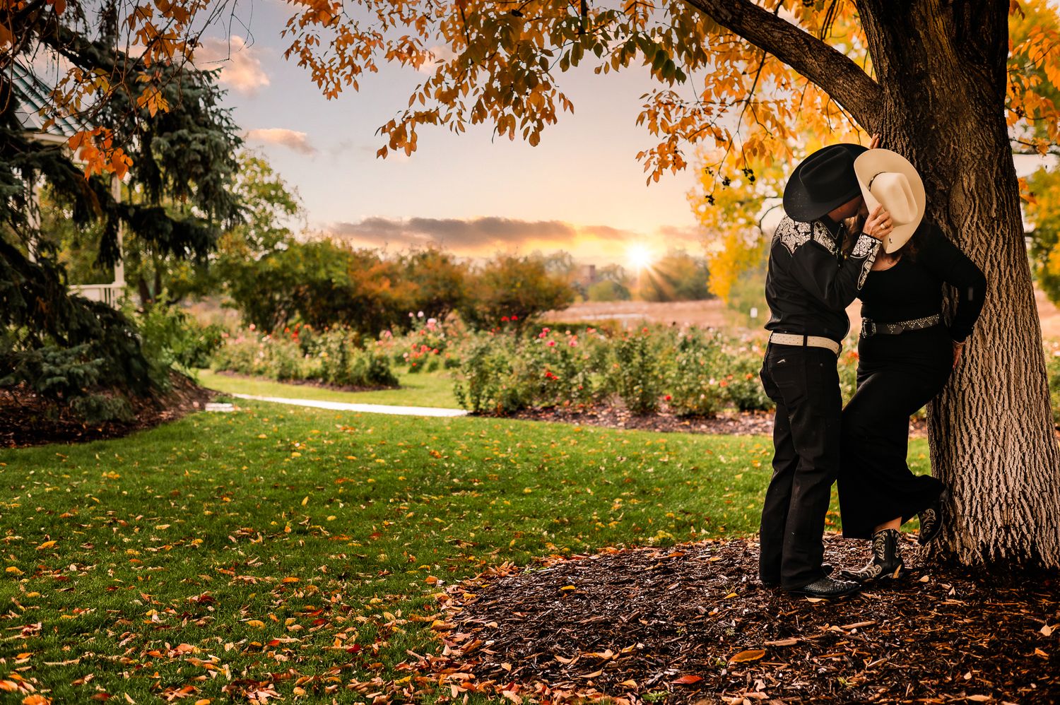 husband kissing his wife against a tree in a Littleton co park
