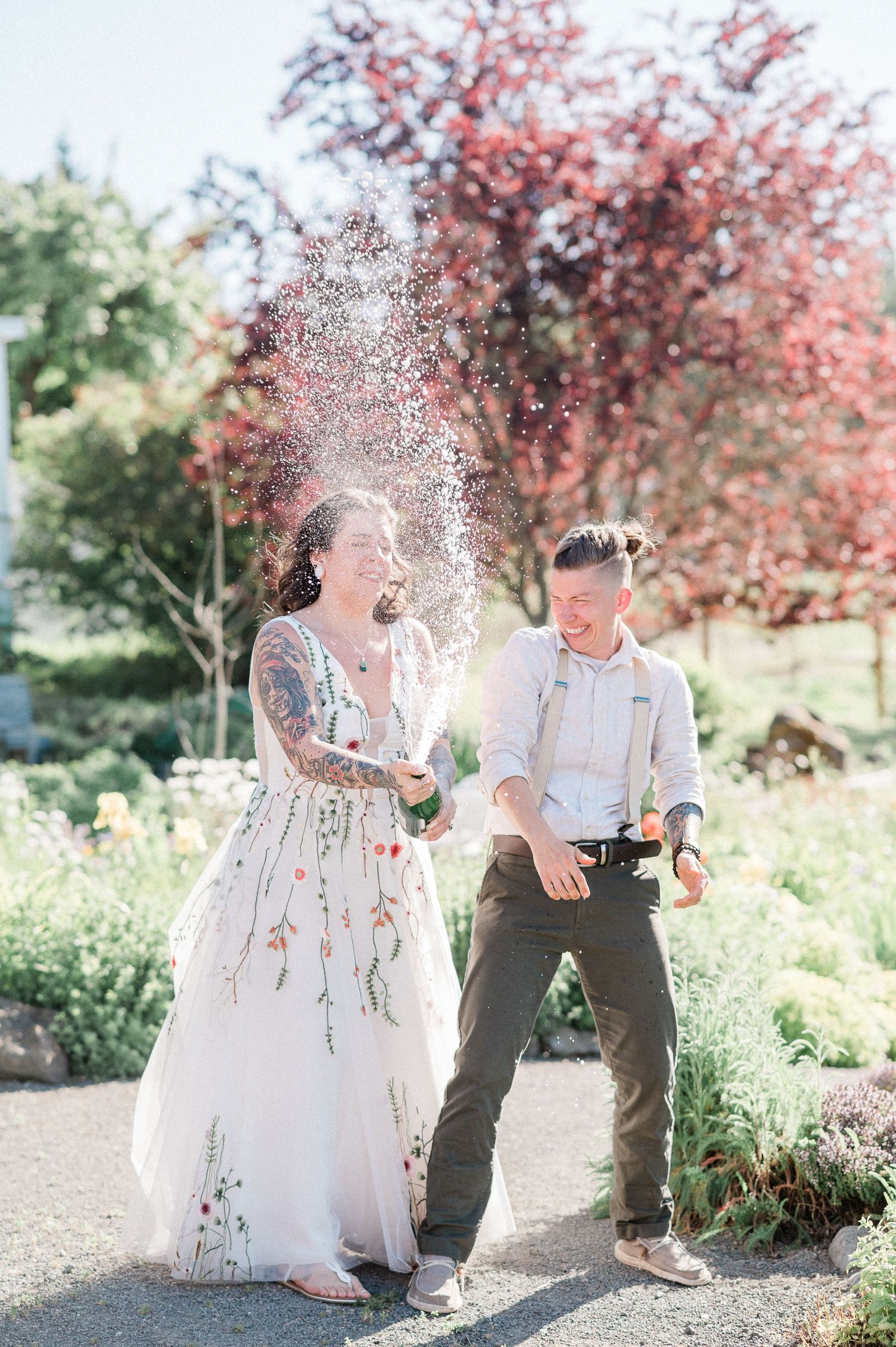 couple spraying champagne on their wedding day. Photo by Sequim Elopement Photographer,  Pine + Vow