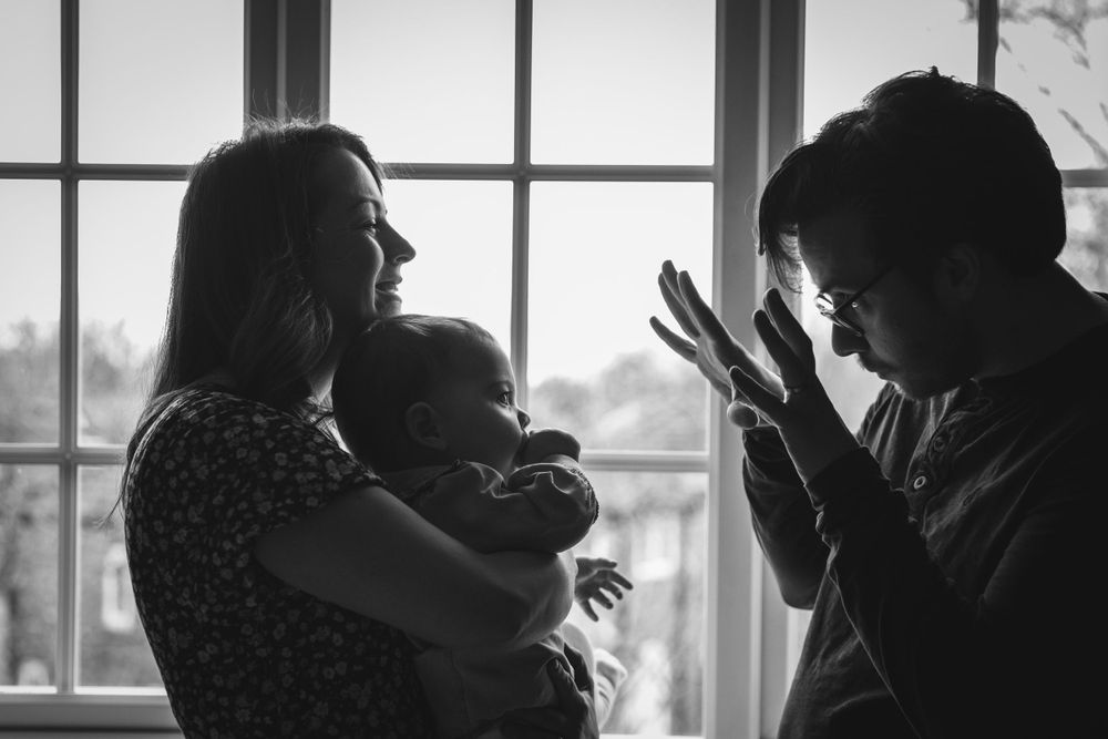 A silhouetted family scene by a window showing animated interaction.
