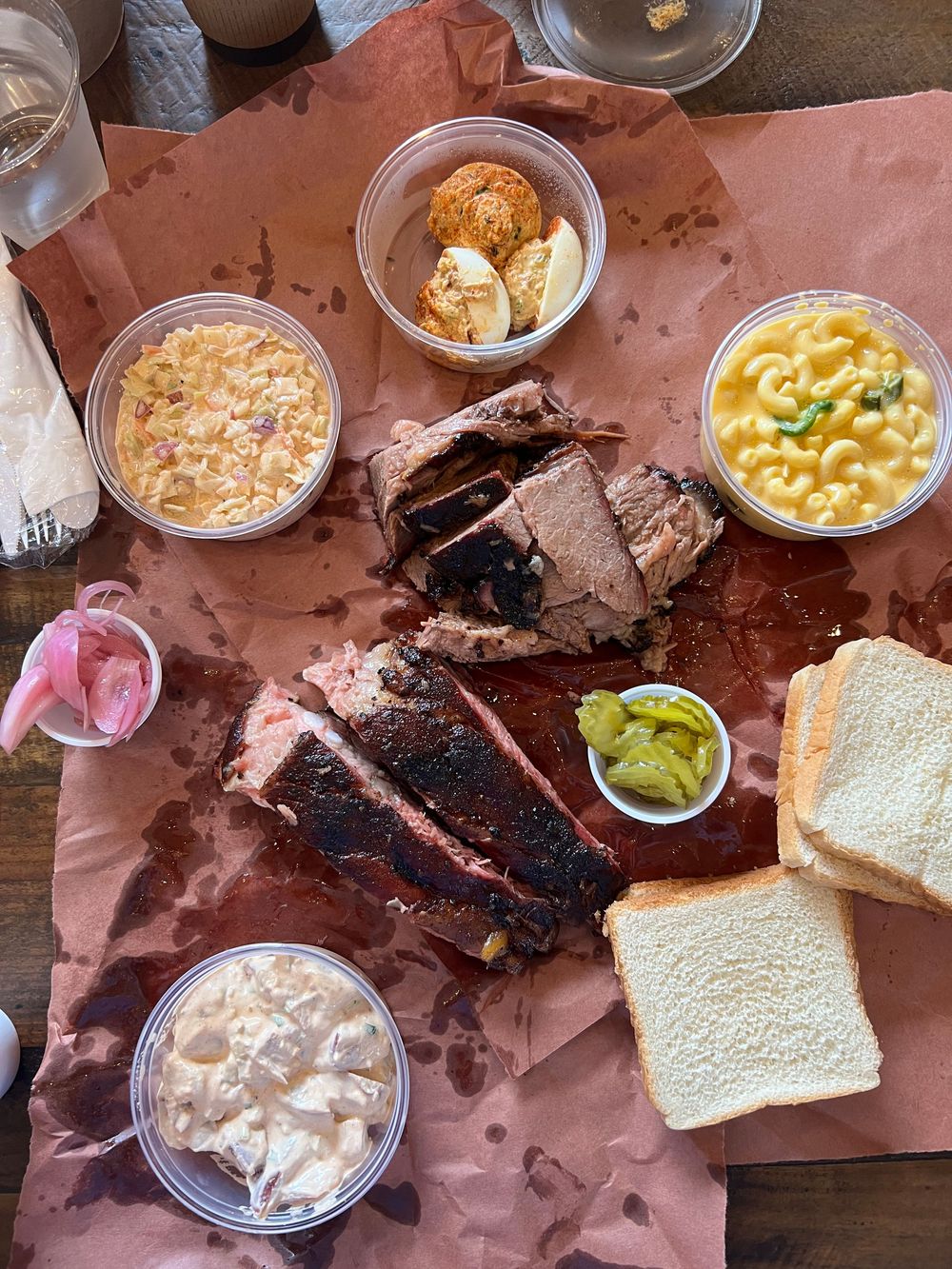 Texas BBQ spread with brisket, ribs, mac and cheese, coleslaw, and white bread.