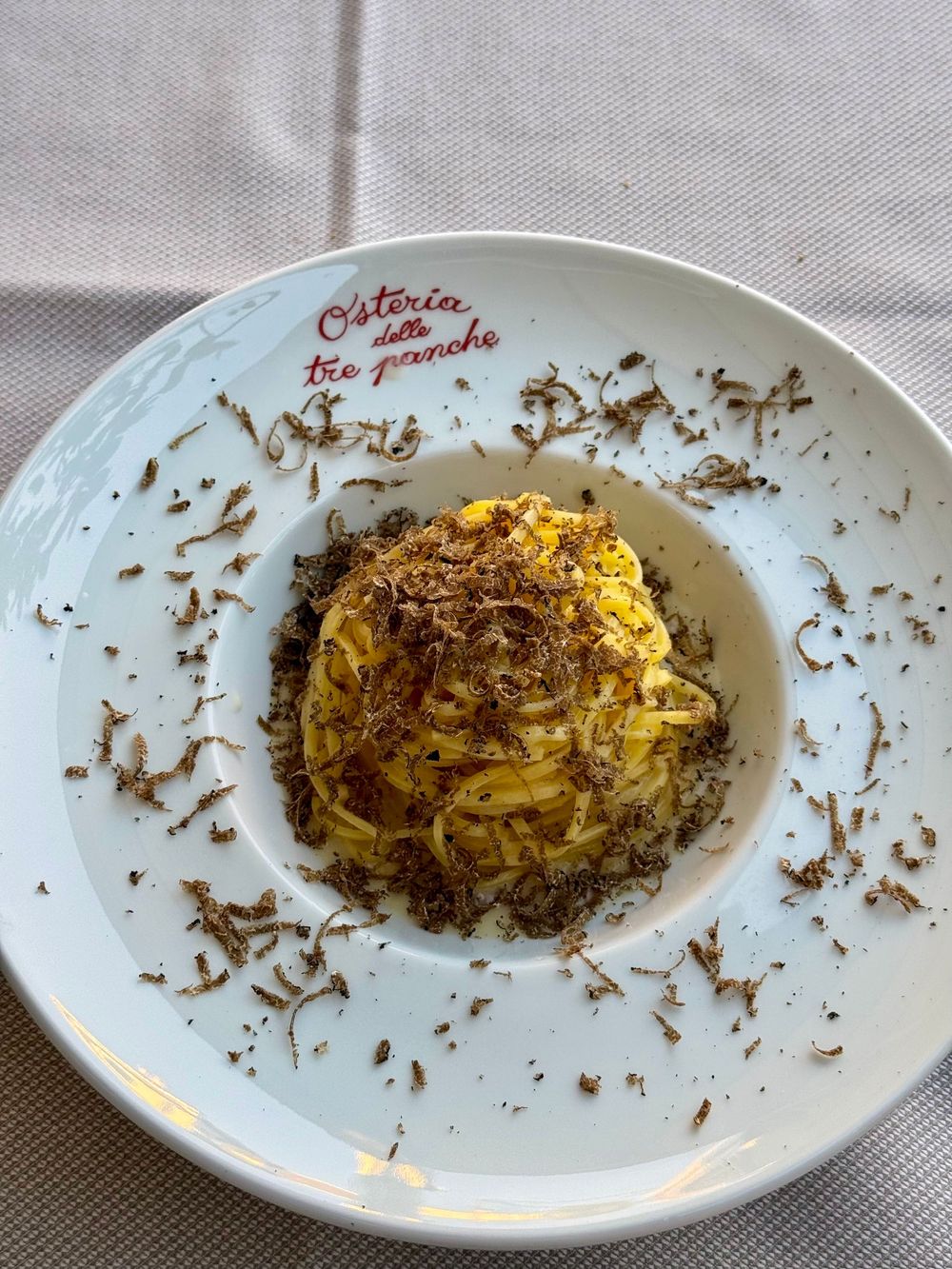 Plate of fresh tagliatelle pasta topped with shaved black truffle at Osteria delle Tre Panche restaurant.