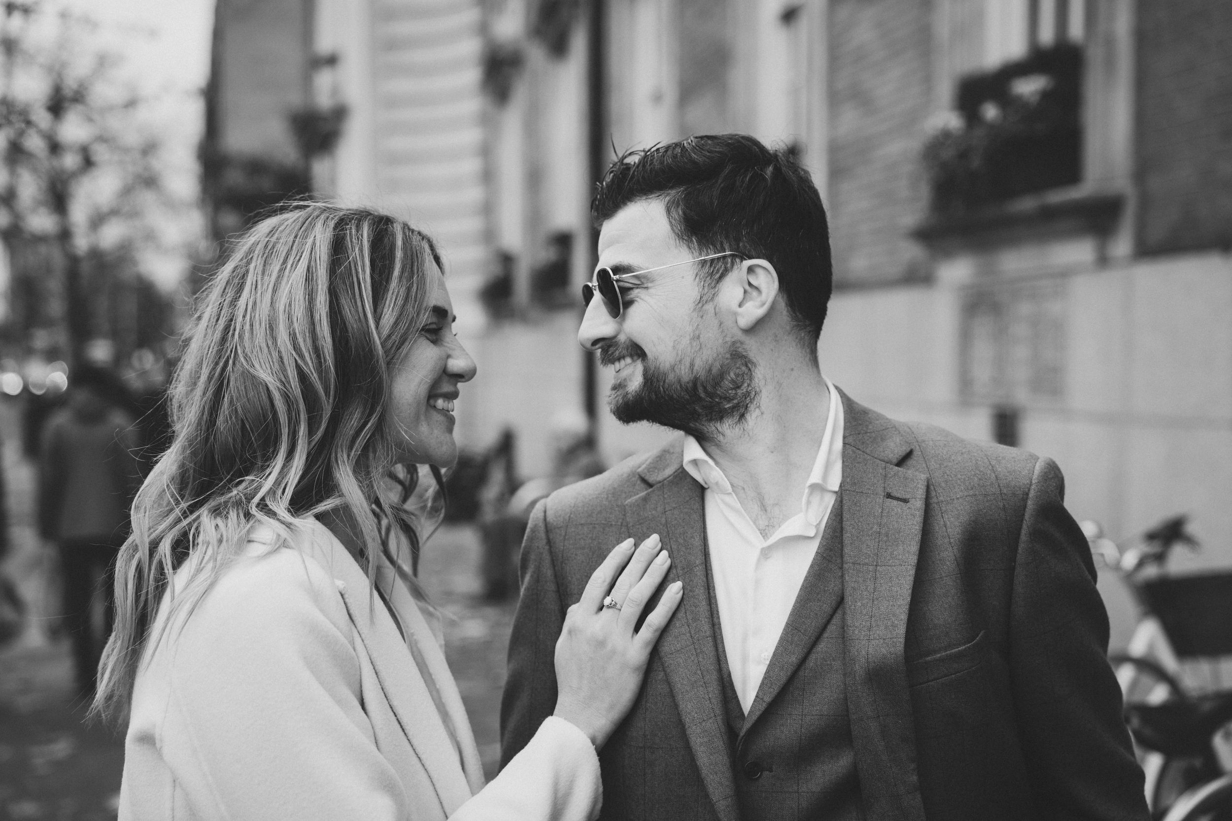 Couple sharing a tender moment on a city street in black and white wedding photo.
