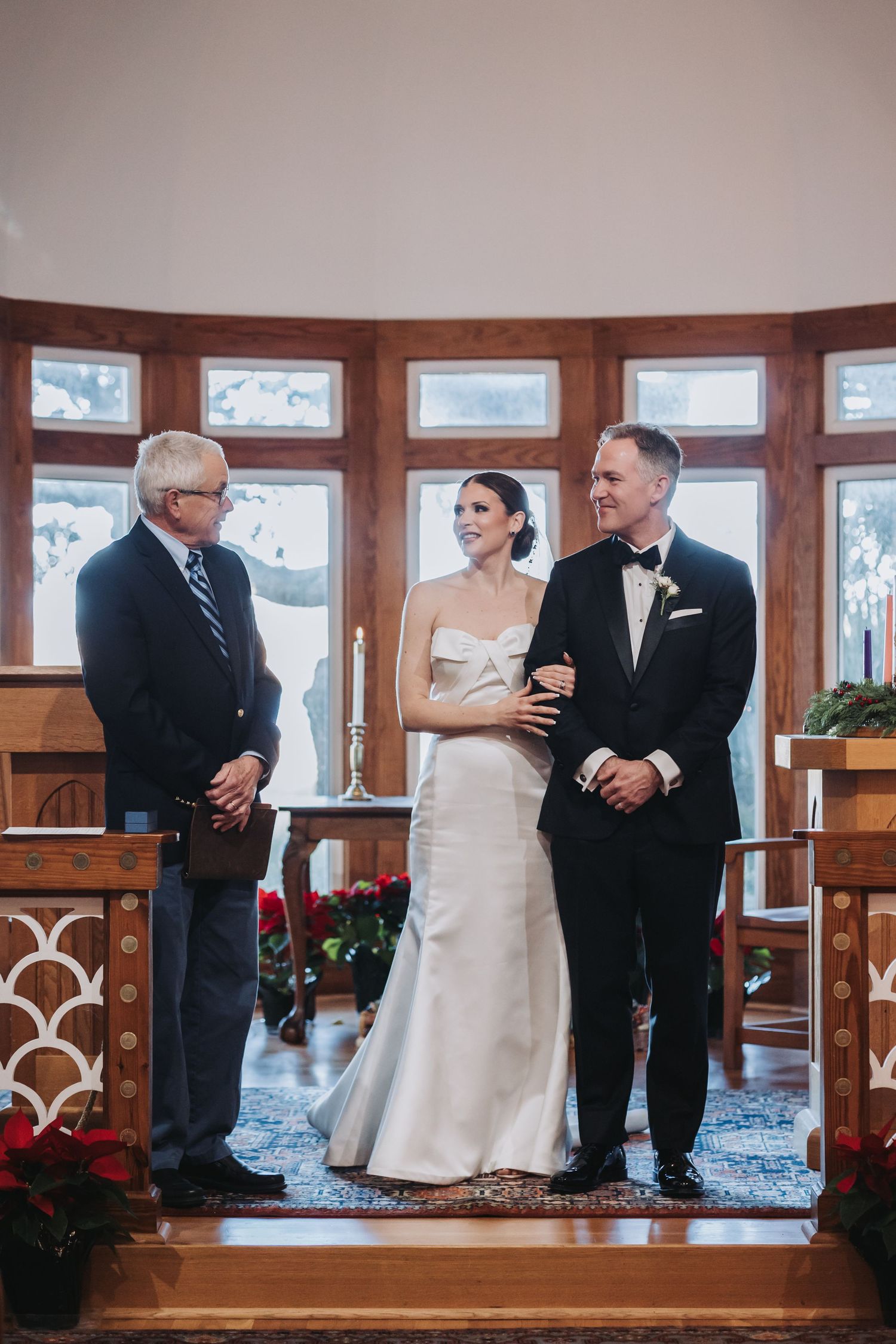 Bride and groom standing at the altar with an officiant during an intimate chapel wedding ceremony.