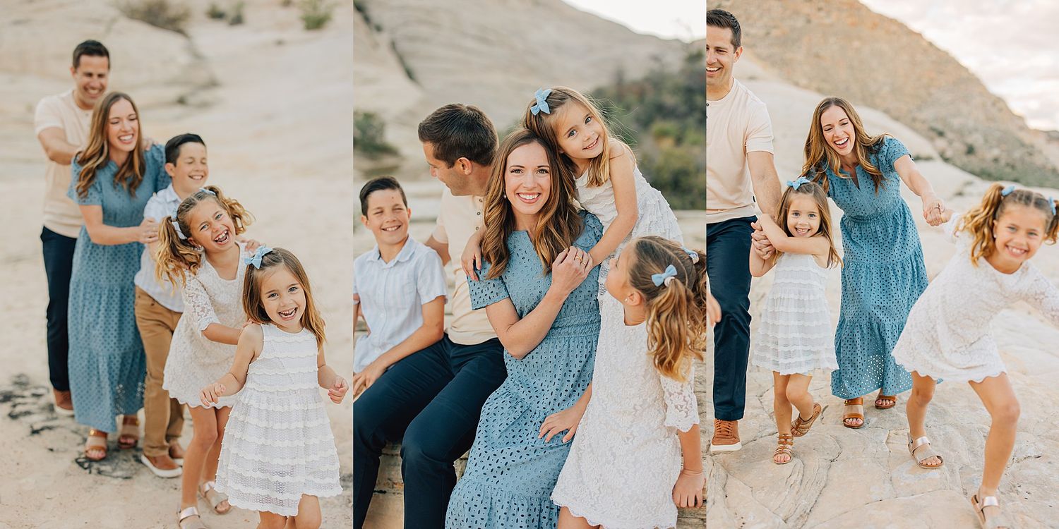 A joyful family poses together on a sandy beach, wearing coordinated blue and white outfits in a bright outdoor setting.