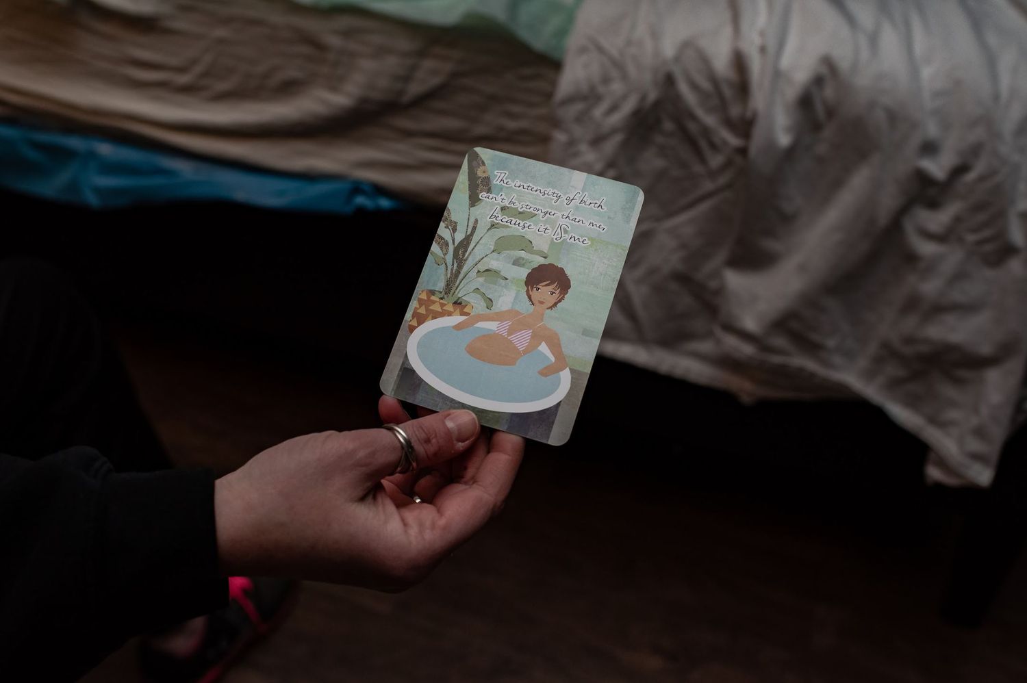 Hand holding vintage-style illustration card featuring mother and baby.