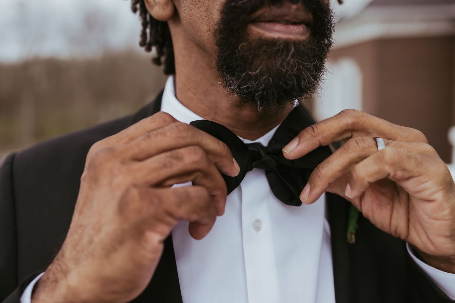 Groom adjusting his tie getting ready for his wedding at Holliday Farms in Zionsville, Indiana