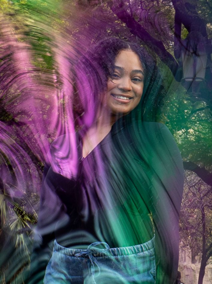 Closer shot of a woman playing with soap bubbles in a garden setting.