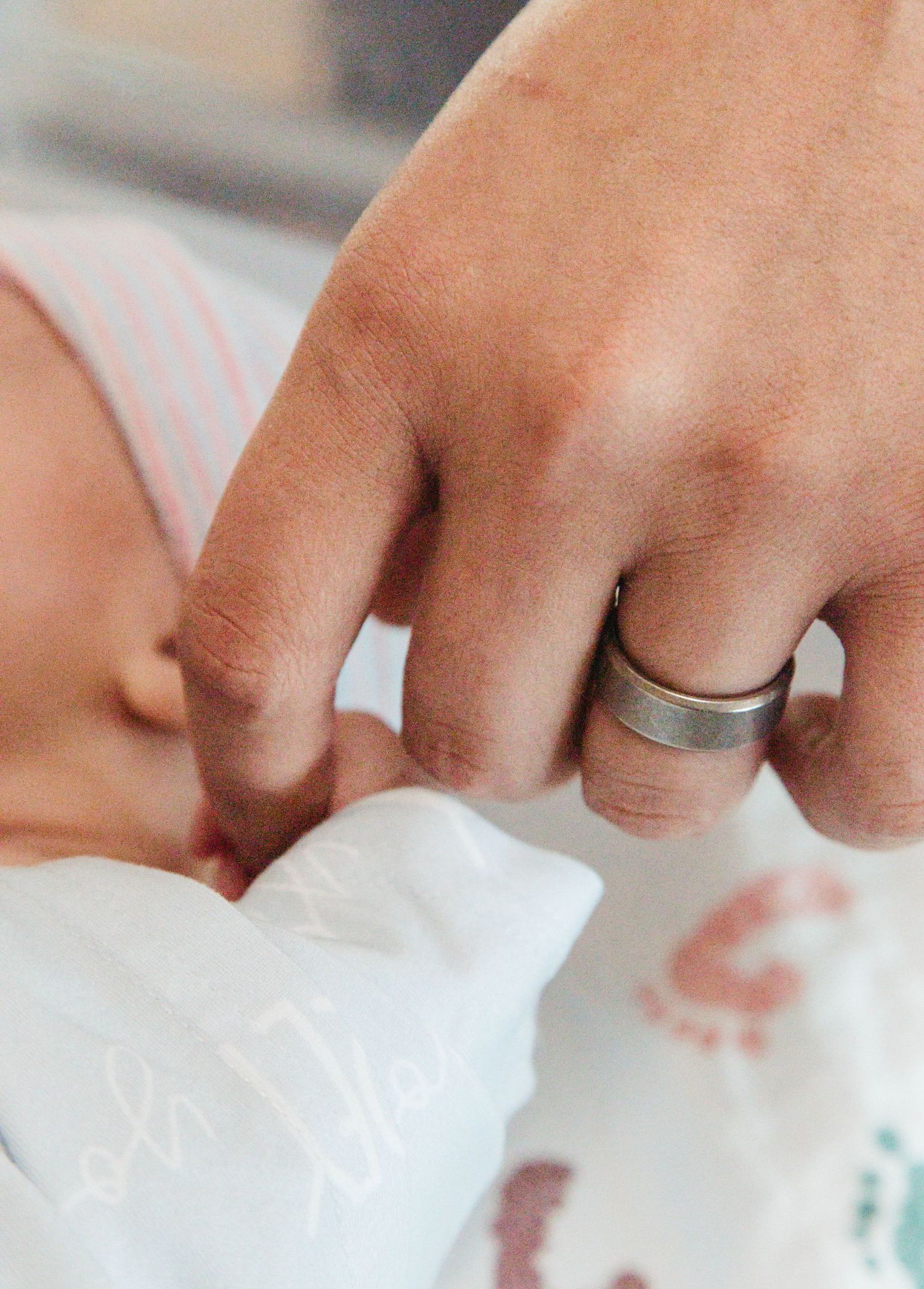 Hands in white gloves carefully handling delicate white paper or tissue material on a light surface.