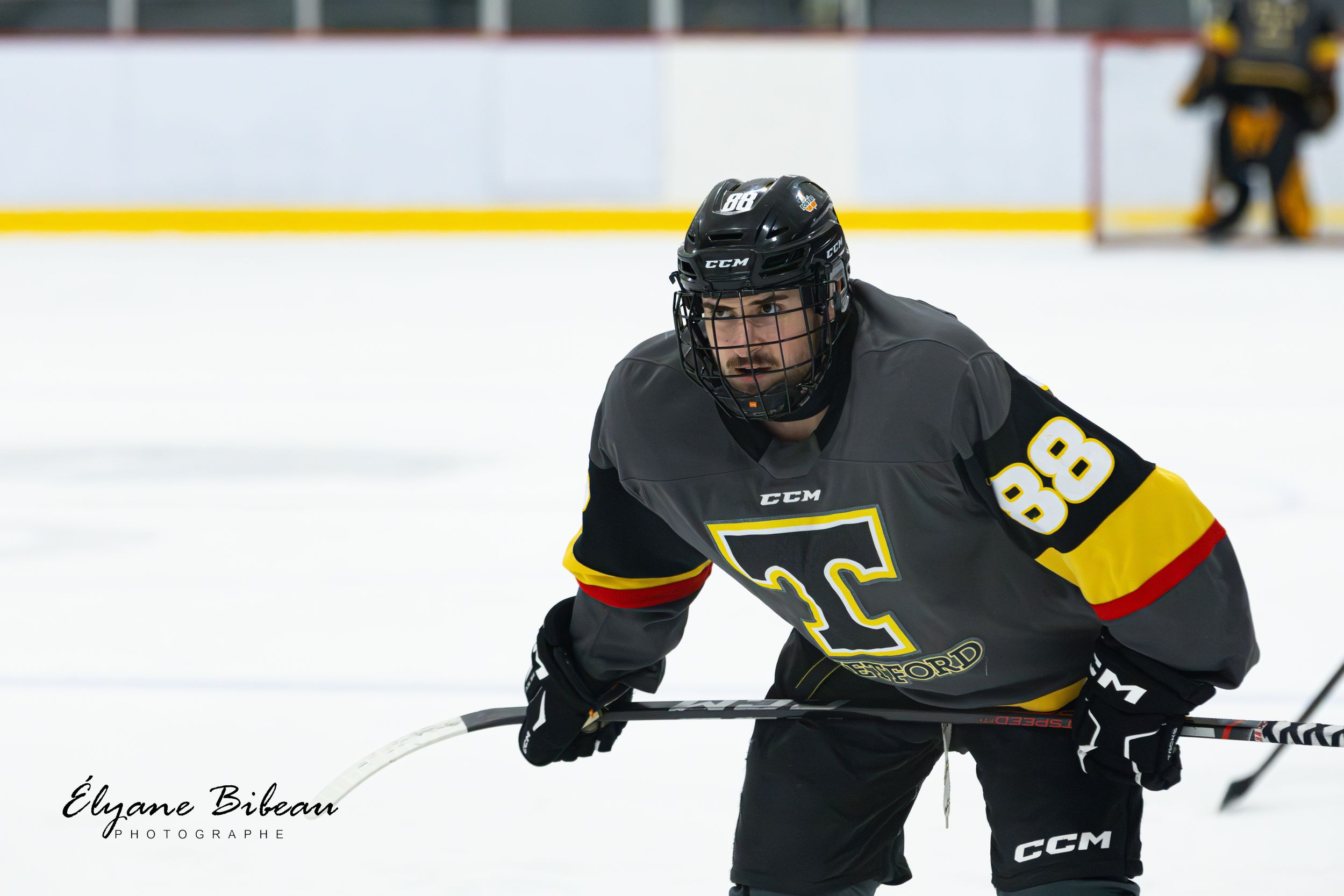 Hockey player in black jersey with number 98 positions for play during ice hockey match.