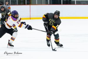 Two opposing hockey players battle for puck control during competitive match.