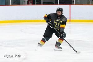 Hockey player in dark uniform makes sharp turn while controlling puck on ice.