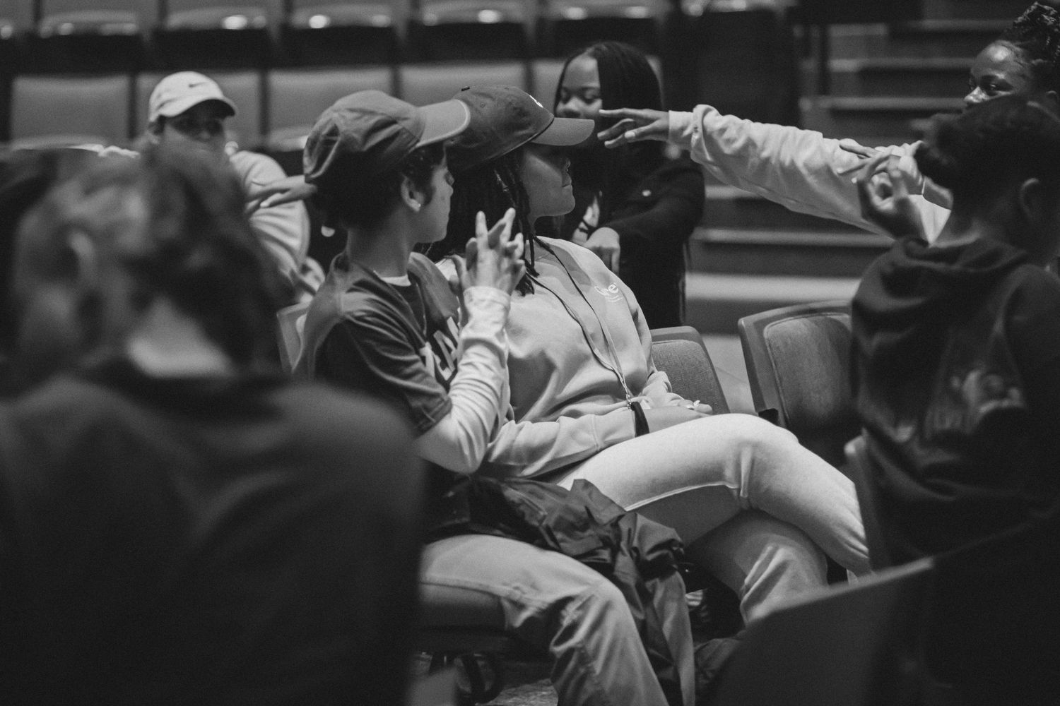 Vintage black and white photo of people sitting in stadium bleachers.