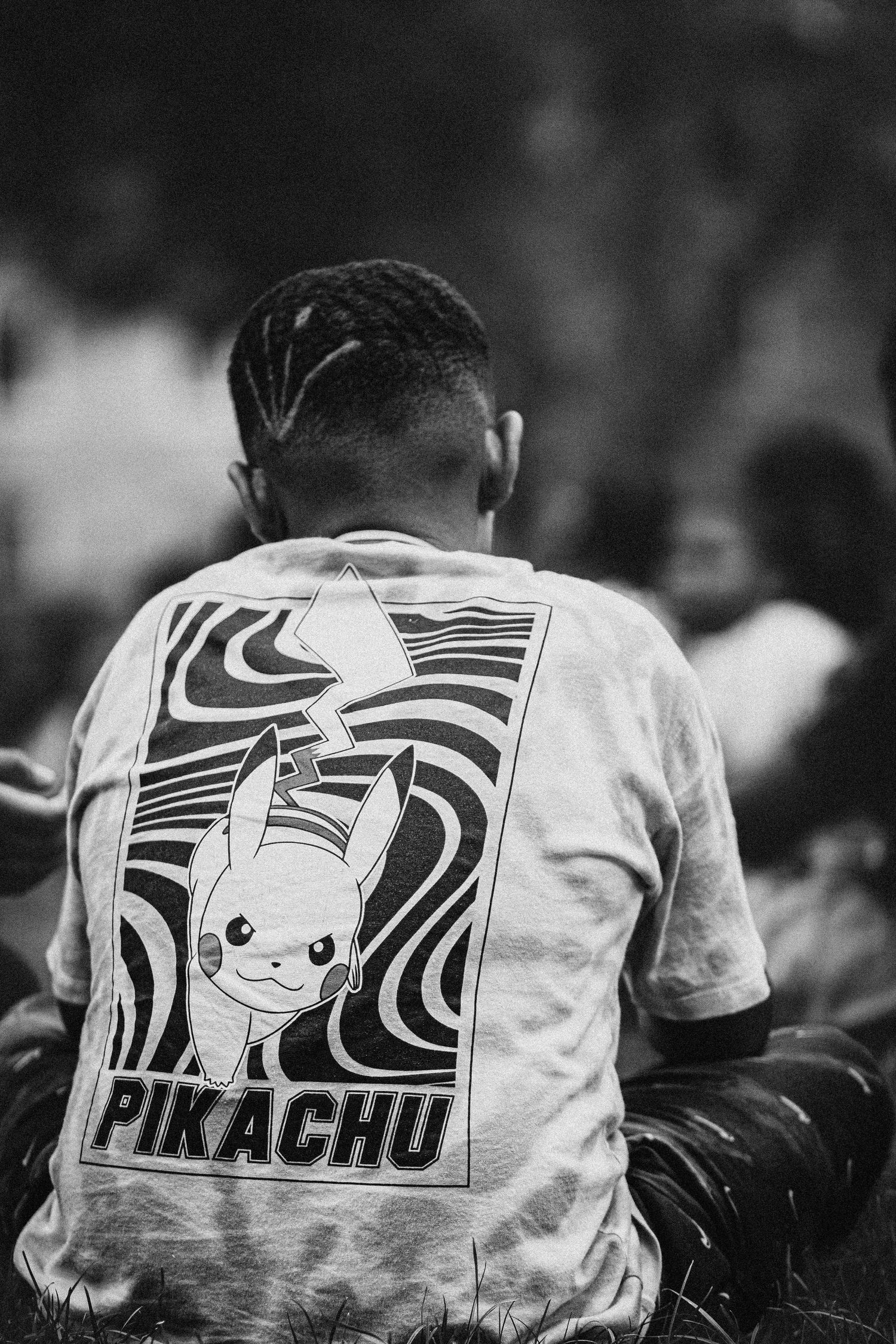 Back view of person wearing t-shirt with Pikachu Pokemon design in black and white.