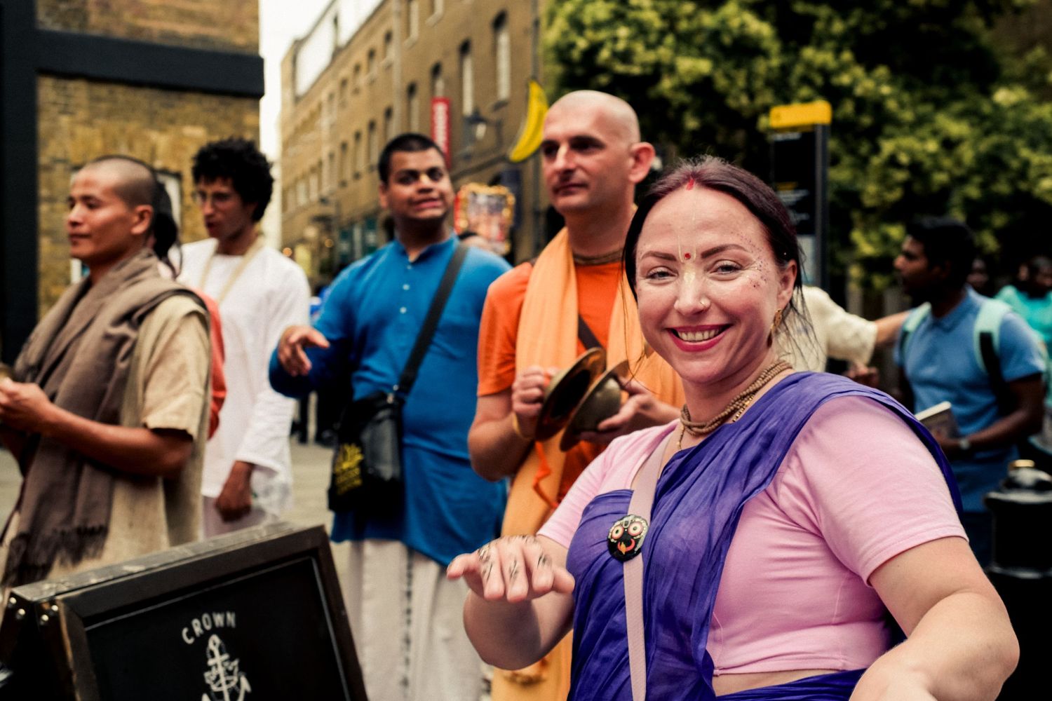 Diverse crowd enjoys street performances in London's historic district.