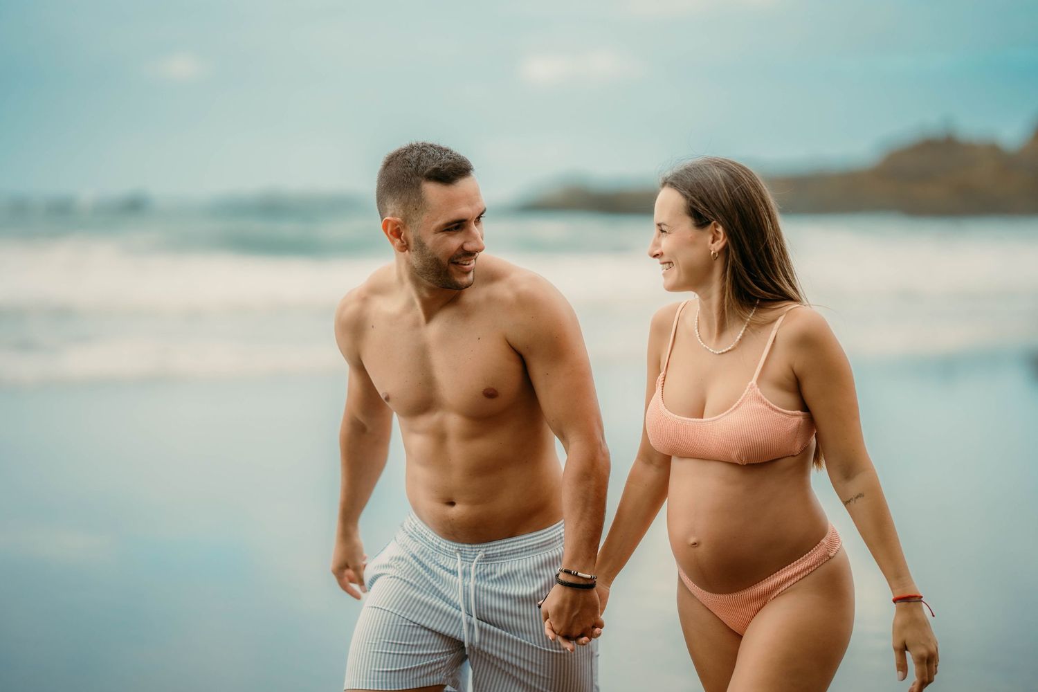 A serene maternity photoshoot at Playa Bollullo, Tenerife, Canary Islands. Celebrating the beauty of motherhood by the ocean's waves.