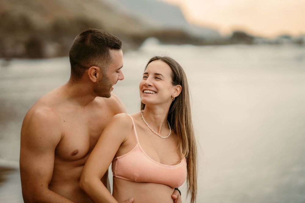 A serene maternity photoshoot at Playa Bollullo, Tenerife, Canary Islands. Celebrating the beauty of motherhood by the ocean's waves.