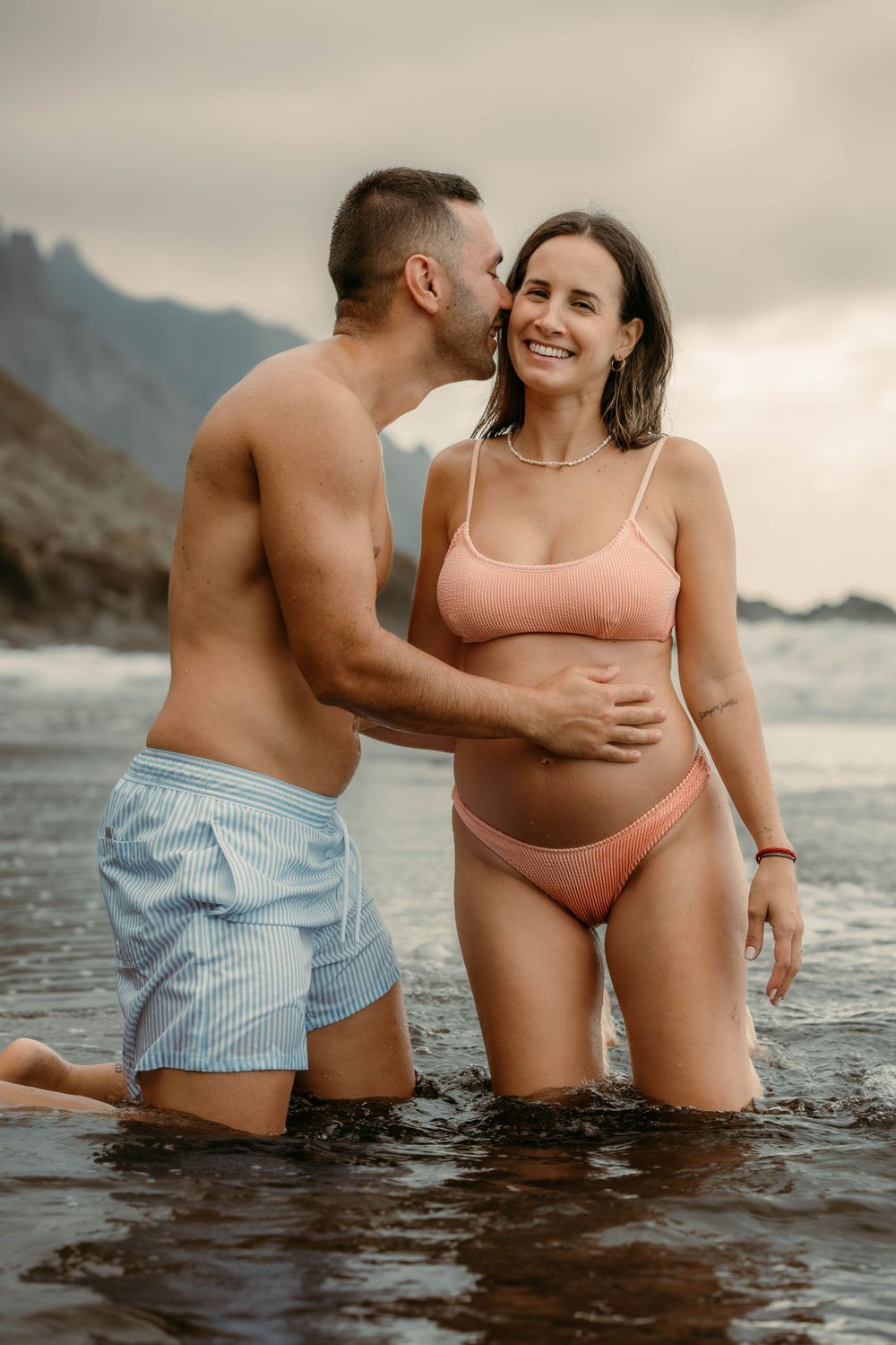 A serene maternity photoshoot at Playa Bollullo, Tenerife, Canary Islands. Celebrating the beauty of motherhood by the ocean's waves.