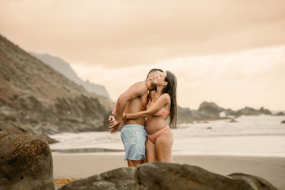 A serene maternity photoshoot at Playa Bollullo, Tenerife, Canary Islands. Celebrating the beauty of motherhood by the ocean's waves.