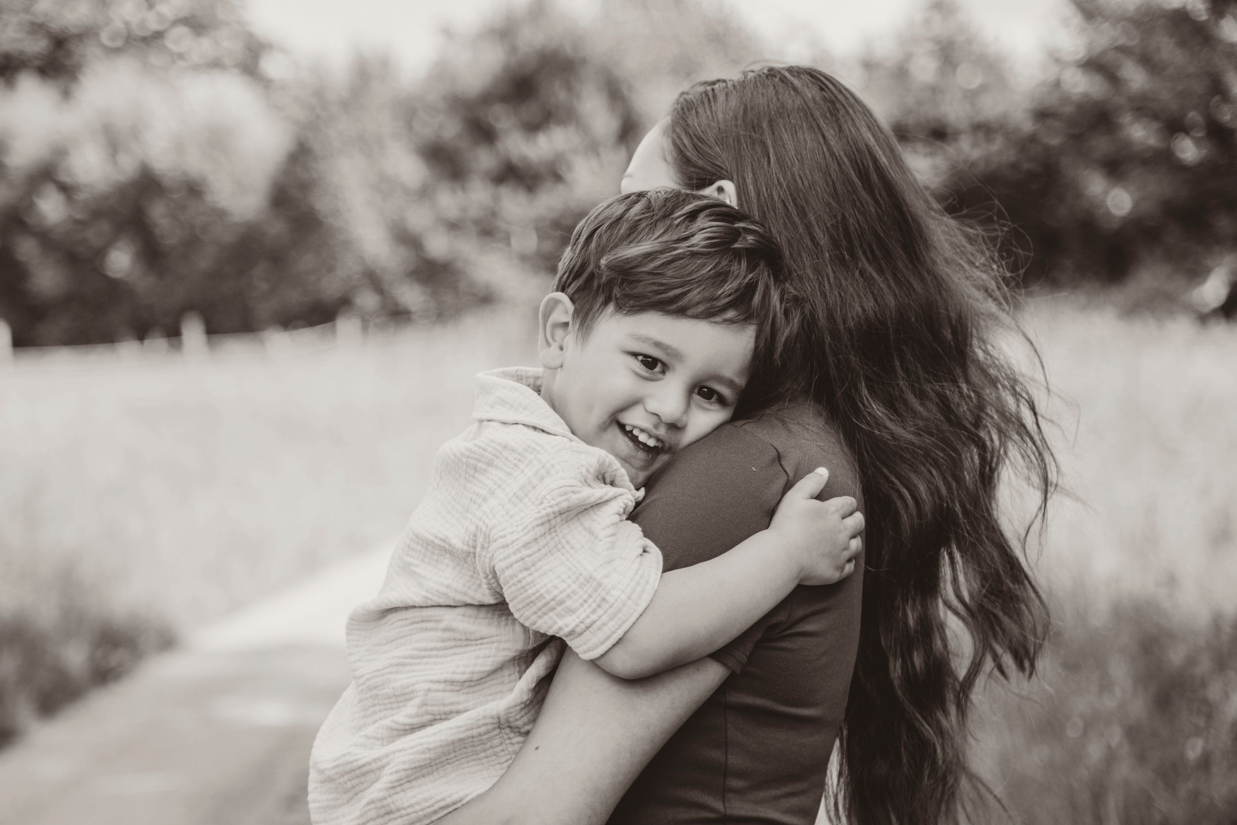 A series of black and white photos showing tender embraces and moments of connection between parent and child.