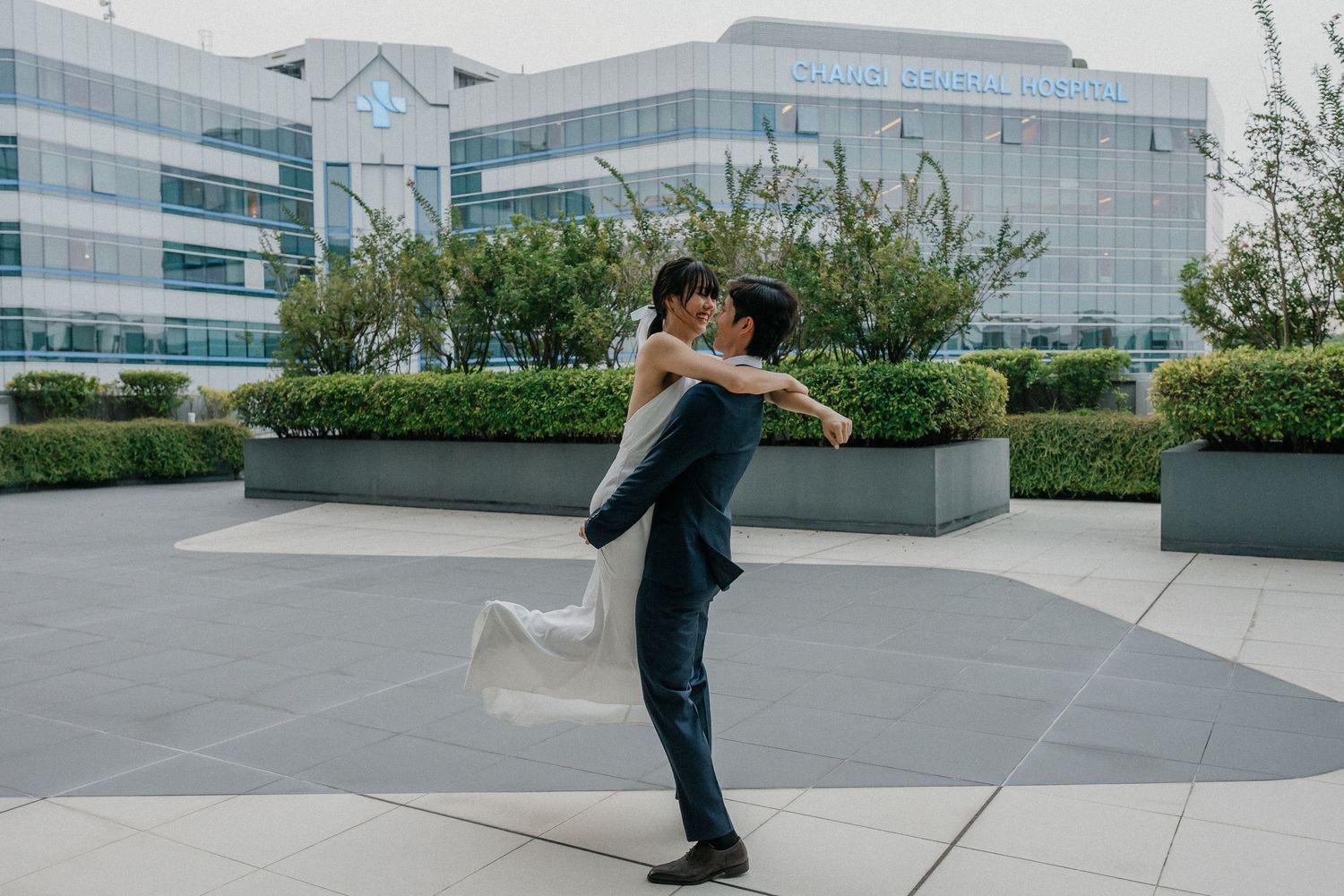 Romantic spin dance captured during wedding photoshoot at modern building.