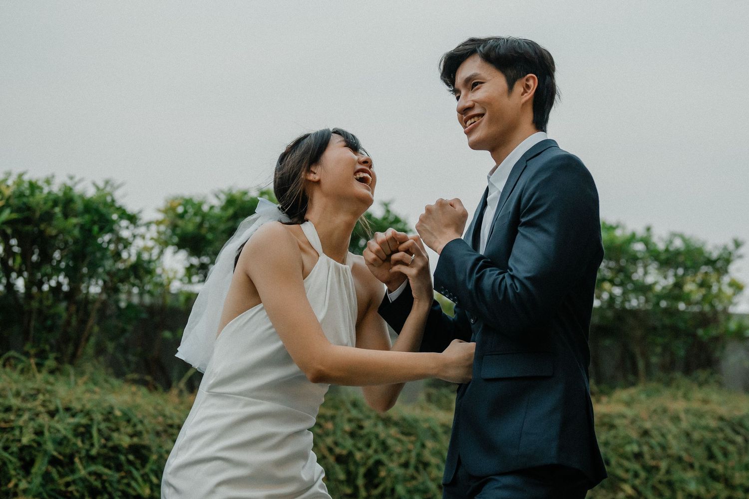 A joyful candid moment of laughter between newlyweds during their outdoor photo session.