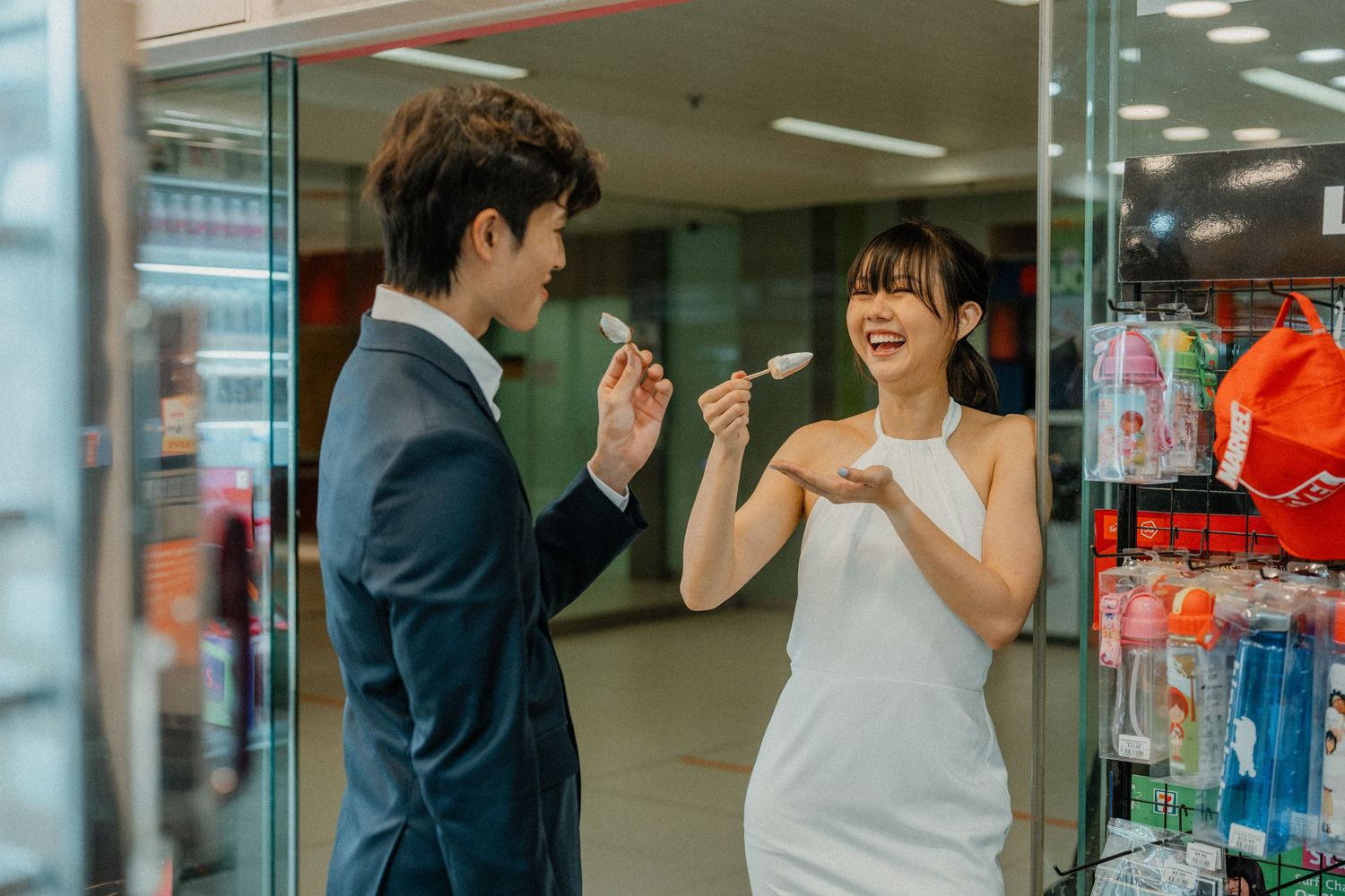 Couple enjoying snacks together inside a convenience store.