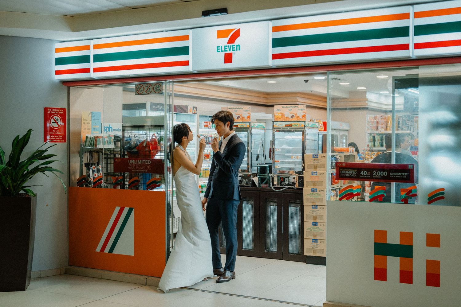 Formally dressed couple poses at the entrance of a 7-Eleven store.