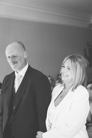 A couple sharing joyful moments in formal black and white attire.