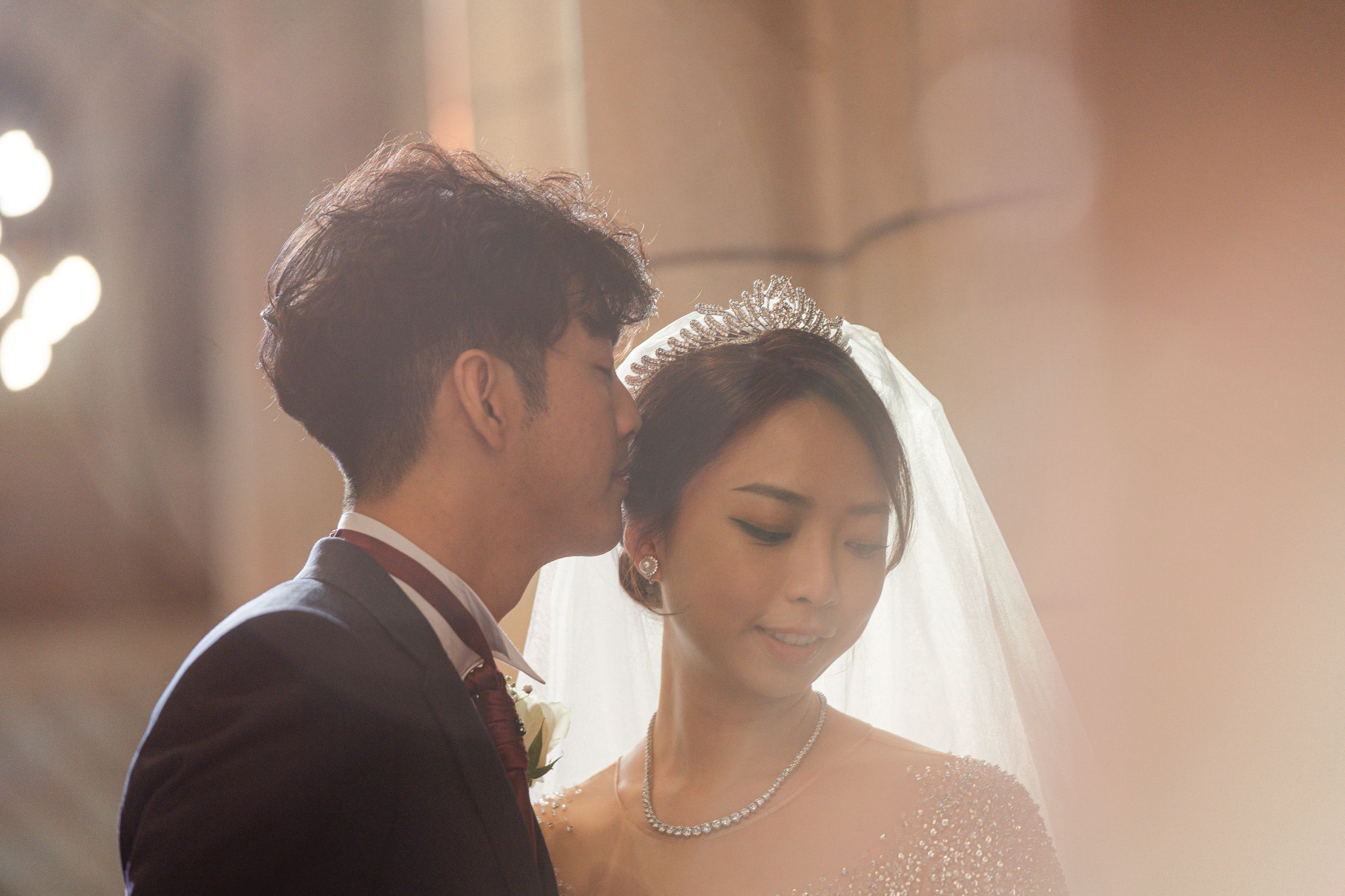 Romantic close-up of couple sharing tender moment in elegant wedding attire.