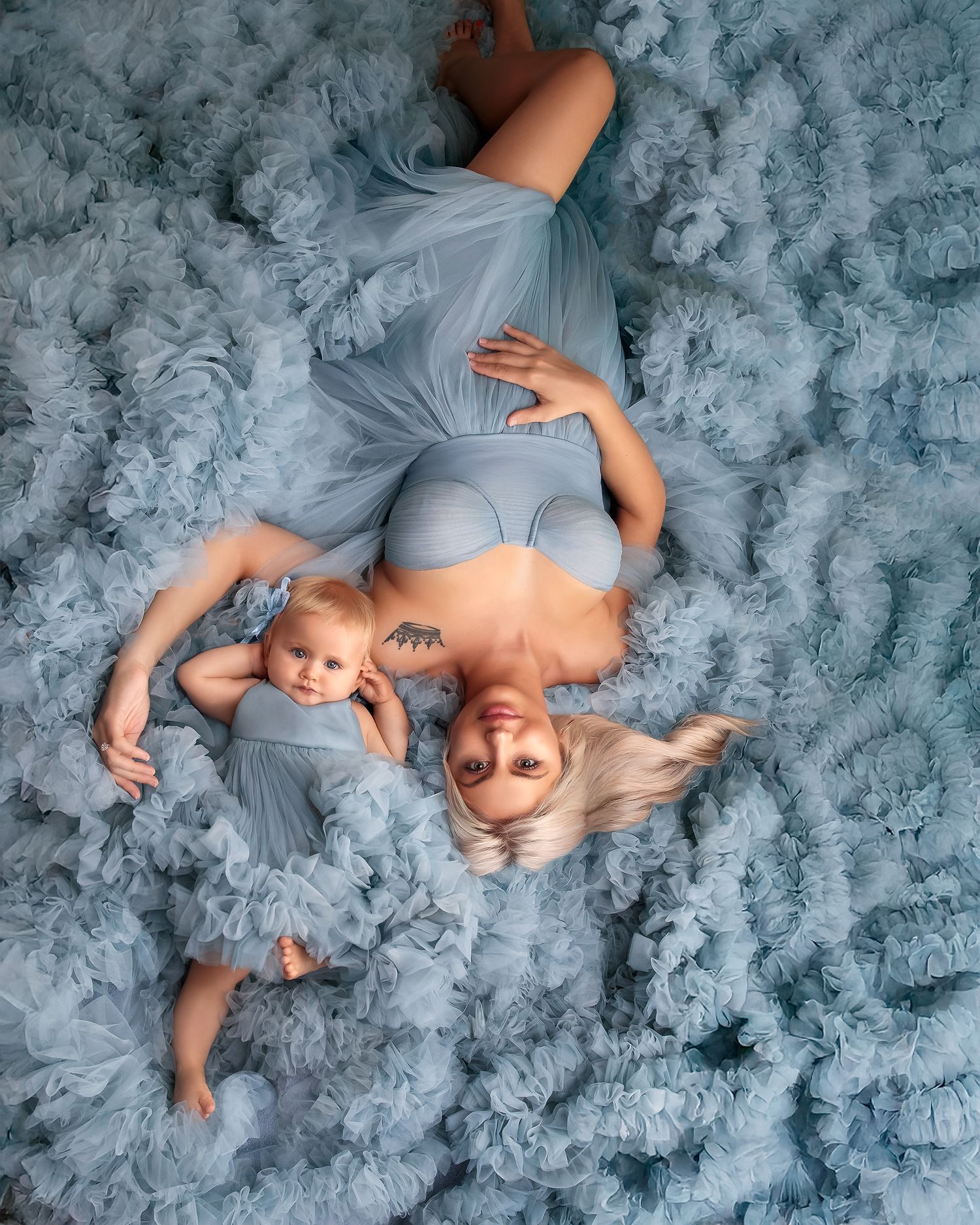 Caz Captures photo of a glamorous mother and baby girl laying down together in powder blue couture gowns in Sydney