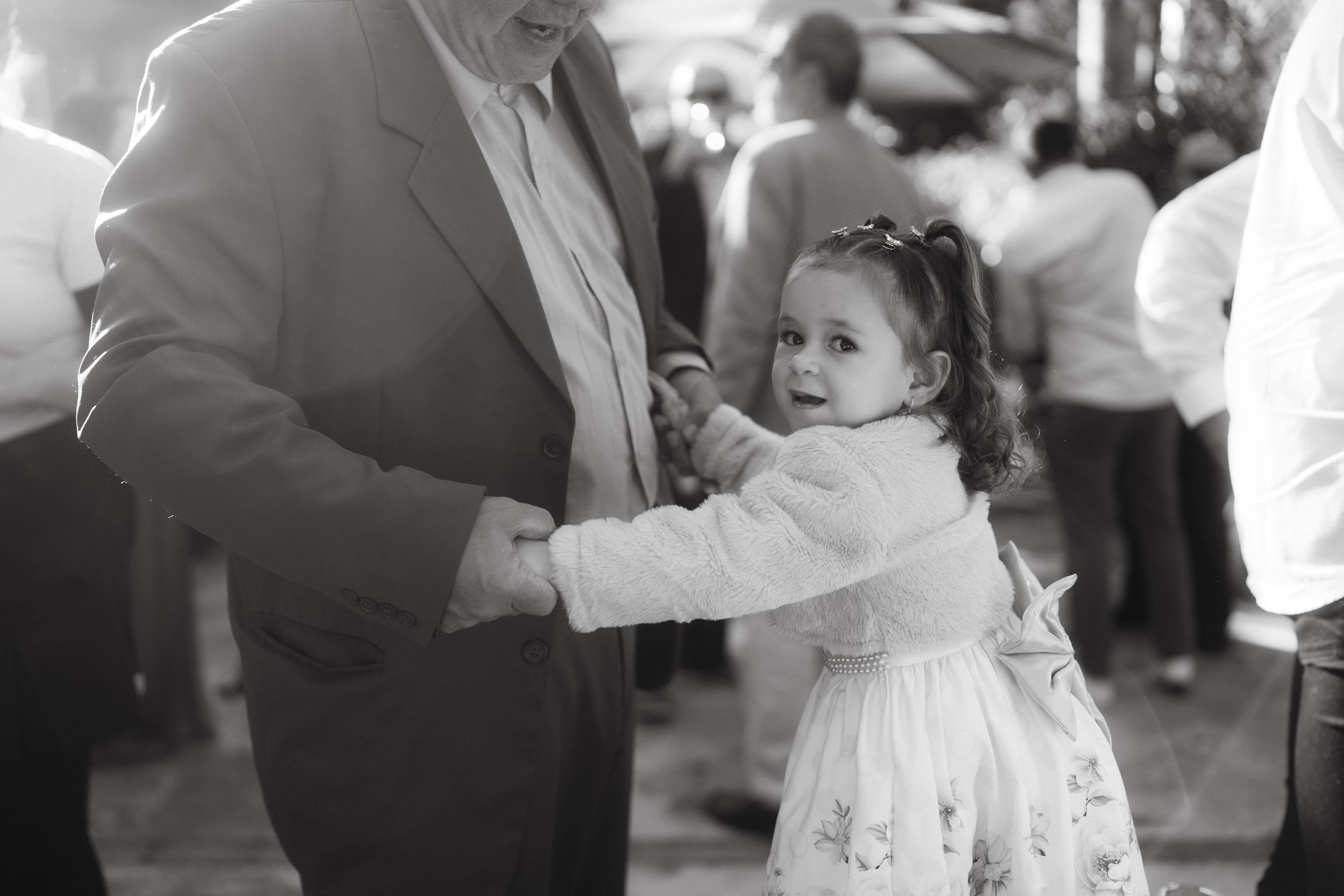Black and white candid dance moments at an outdoor celebration.
