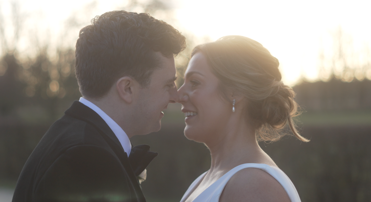 Romantic silhouette of newlyweds sharing an intimate moment at sunset.