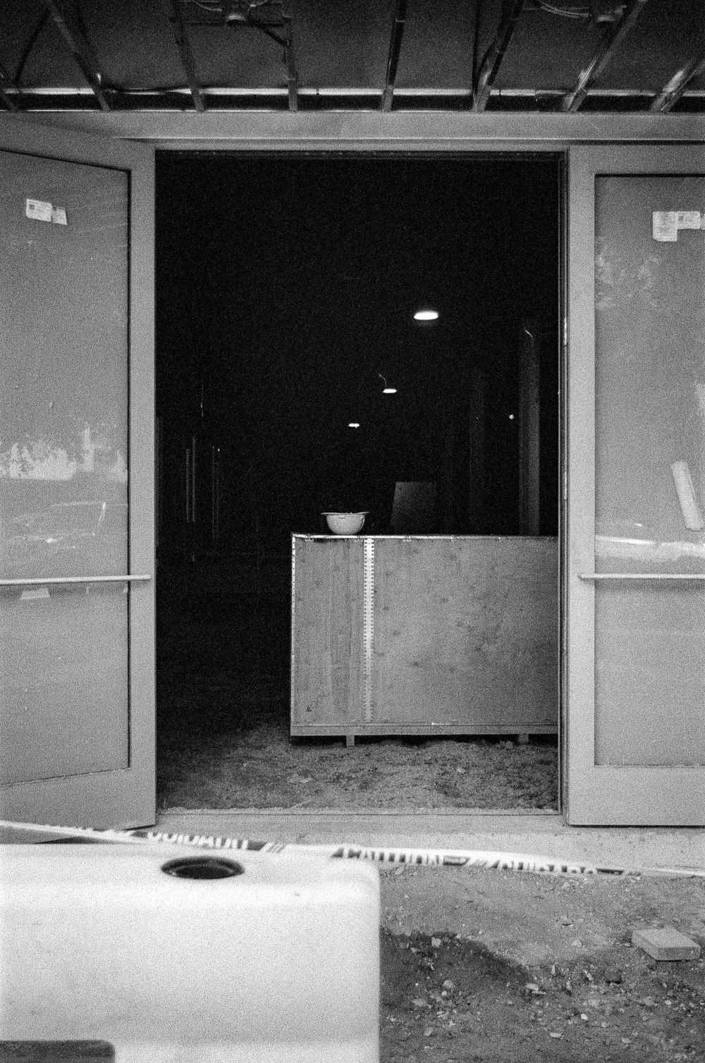 Dark industrial doorway with a counter visible inside and worn concrete floor.